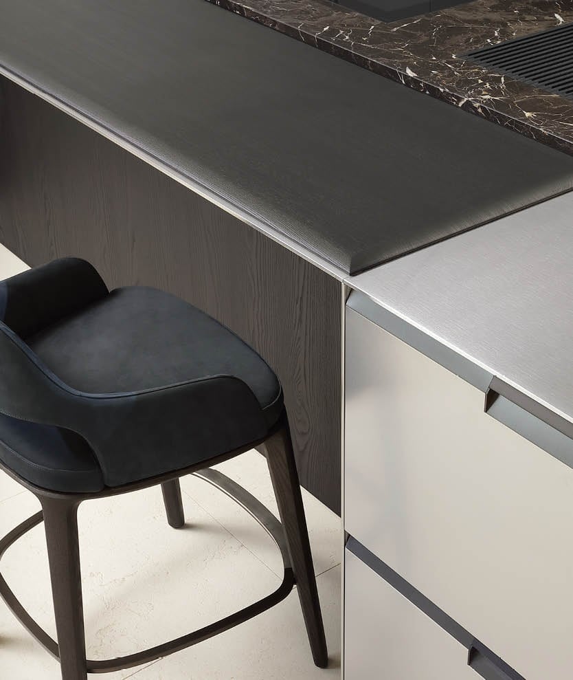 Island bar edge in oak and stone with an upholstered counter stool